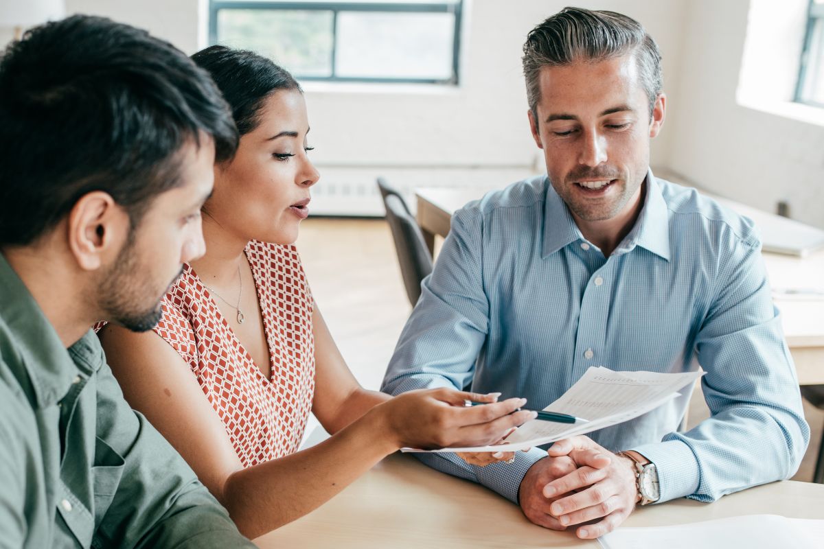 A couple reviewing personal finance paperwork with a broker